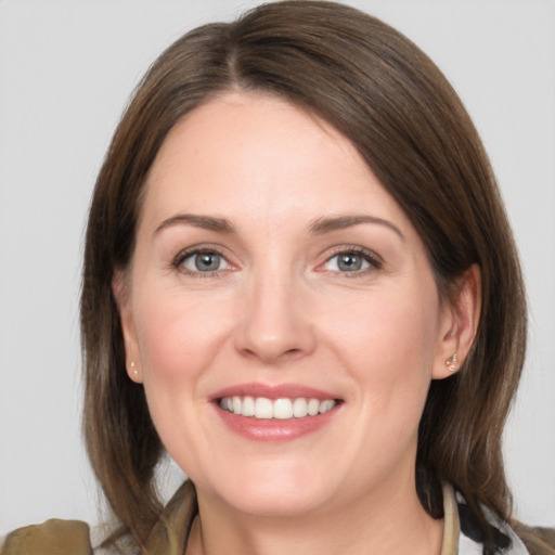 Joyful white young-adult female with medium  brown hair and grey eyes