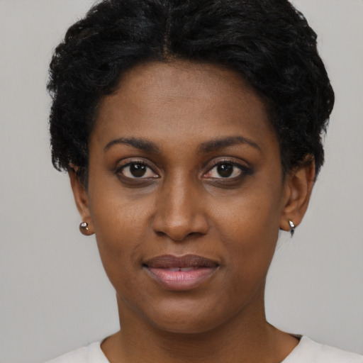 Joyful black young-adult female with short  black hair and brown eyes