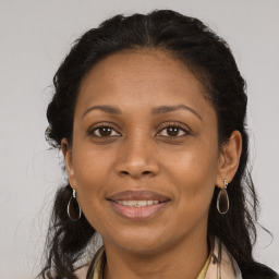 Joyful black adult female with long  brown hair and brown eyes