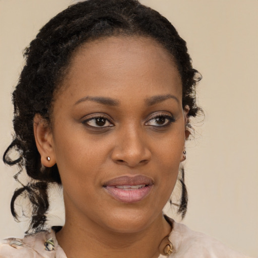 Joyful black young-adult female with long  brown hair and brown eyes