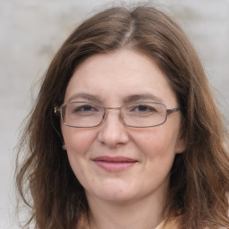 Joyful white adult female with long  brown hair and grey eyes