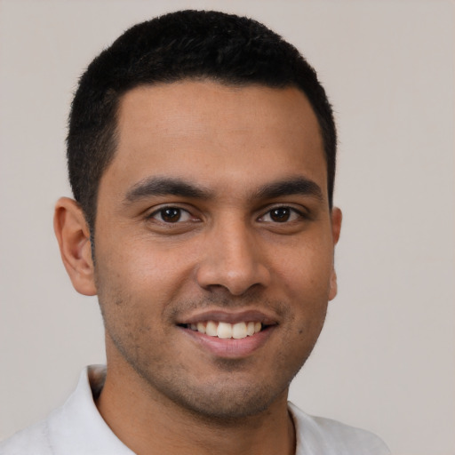 Joyful latino young-adult male with short  brown hair and brown eyes