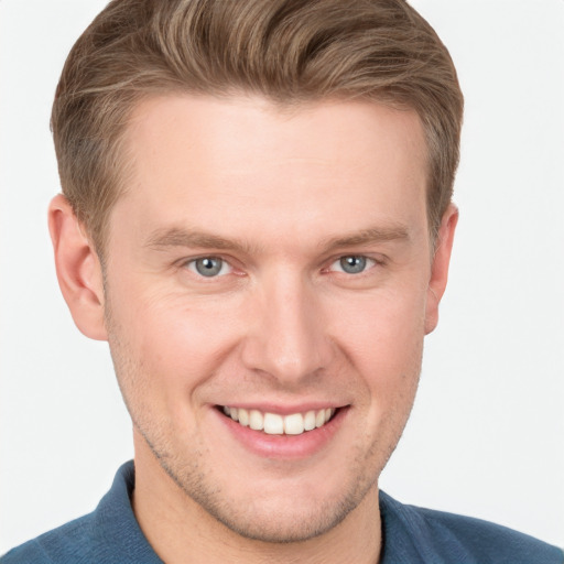 Joyful white young-adult male with short  brown hair and grey eyes