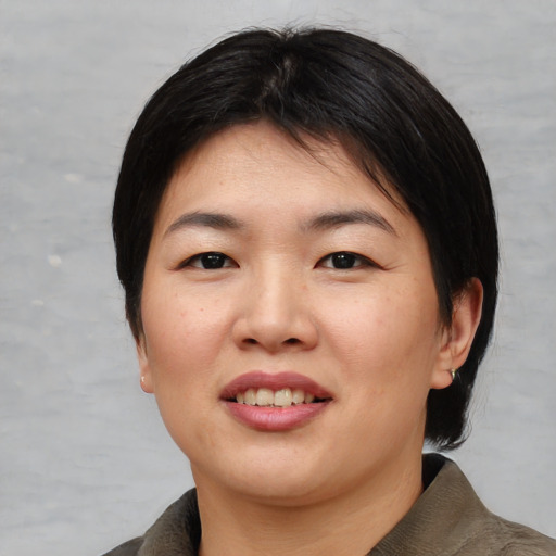 Joyful asian young-adult female with medium  black hair and brown eyes