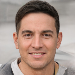 Joyful white adult male with short  brown hair and brown eyes