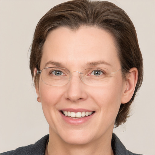 Joyful white adult female with medium  brown hair and grey eyes