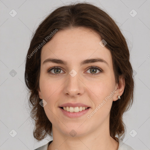 Joyful white young-adult female with medium  brown hair and green eyes