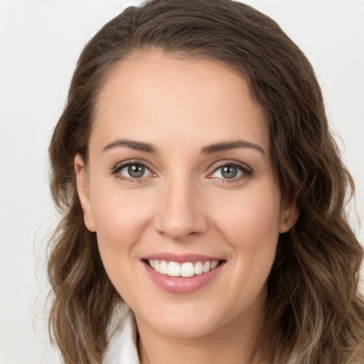 Joyful white young-adult female with long  brown hair and green eyes