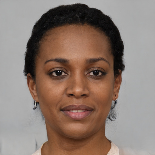 Joyful black young-adult female with short  black hair and brown eyes