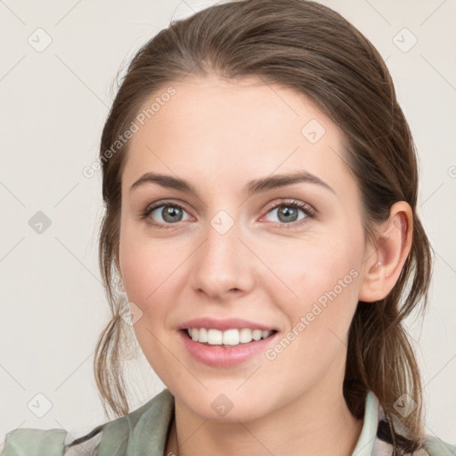 Joyful white young-adult female with medium  brown hair and grey eyes