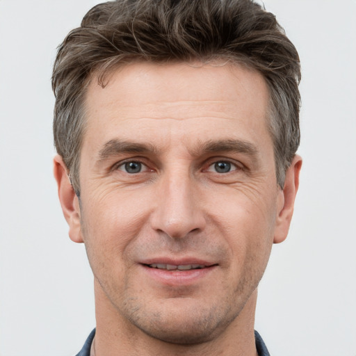 Joyful white adult male with short  brown hair and grey eyes