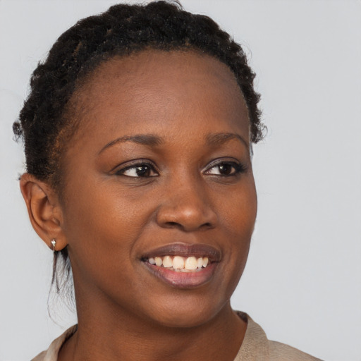 Joyful black young-adult female with short  brown hair and brown eyes