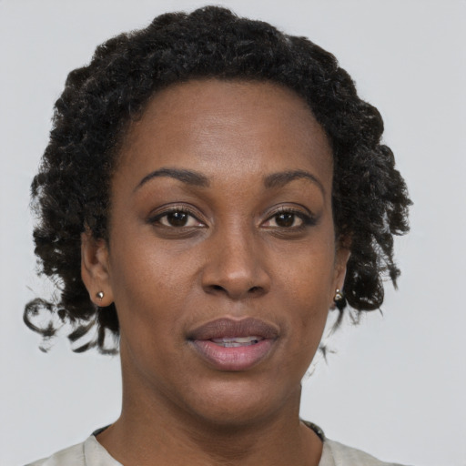 Joyful black adult female with short  brown hair and brown eyes