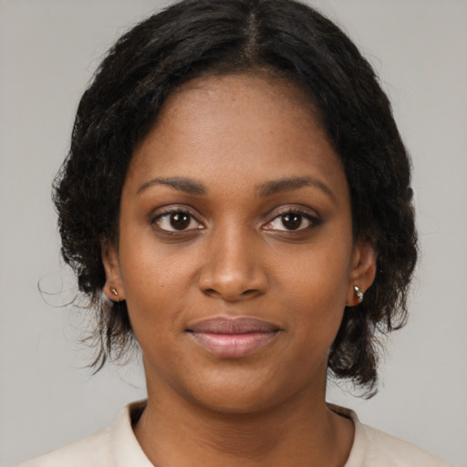 Joyful black young-adult female with medium  black hair and brown eyes