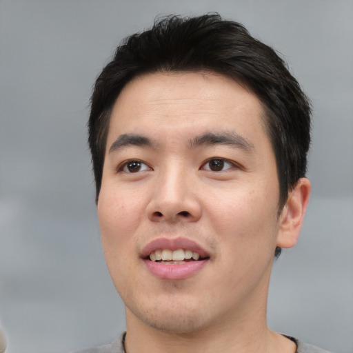 Joyful asian young-adult male with short  black hair and brown eyes