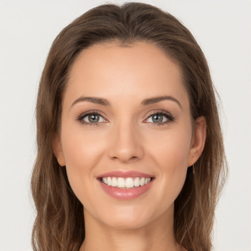 Joyful white young-adult female with long  brown hair and grey eyes