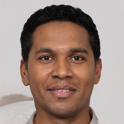 Joyful latino young-adult male with short  black hair and brown eyes