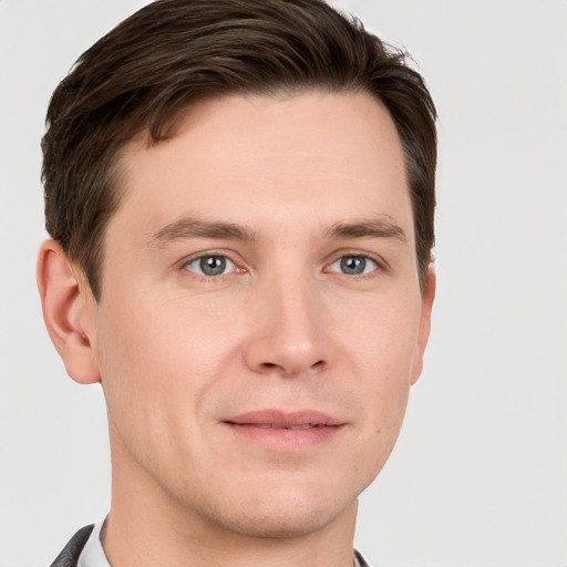 Joyful white young-adult male with short  brown hair and grey eyes