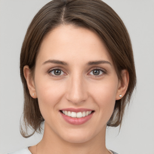 Joyful white young-adult female with medium  brown hair and grey eyes