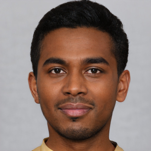 Joyful black young-adult male with short  black hair and brown eyes