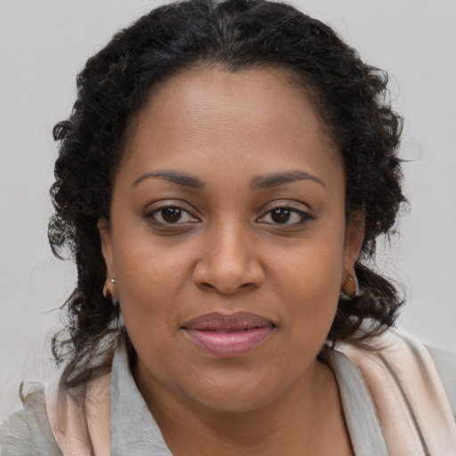Joyful black young-adult female with long  brown hair and brown eyes