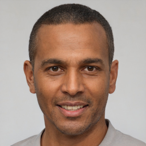 Joyful latino young-adult male with short  brown hair and brown eyes
