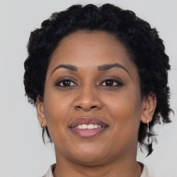 Joyful black young-adult female with short  black hair and brown eyes