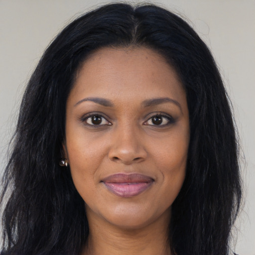 Joyful black young-adult female with long  black hair and brown eyes