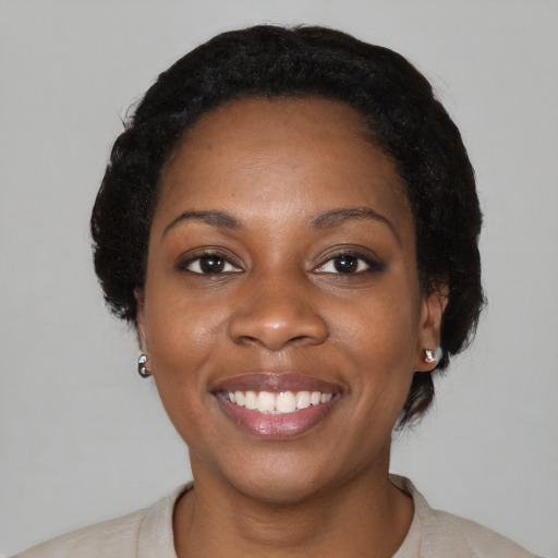 Joyful black young-adult female with medium  black hair and brown eyes