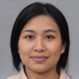 Joyful asian young-adult female with medium  black hair and brown eyes