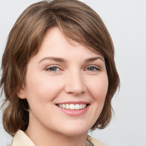 Joyful white young-adult female with medium  brown hair and grey eyes