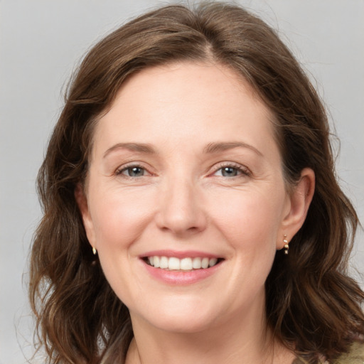 Joyful white young-adult female with medium  brown hair and grey eyes