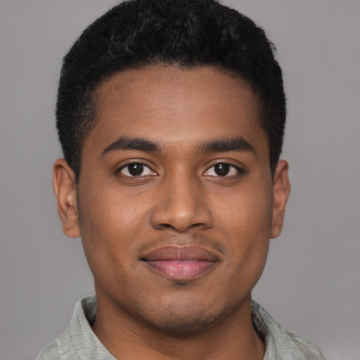 Joyful black young-adult male with short  black hair and brown eyes
