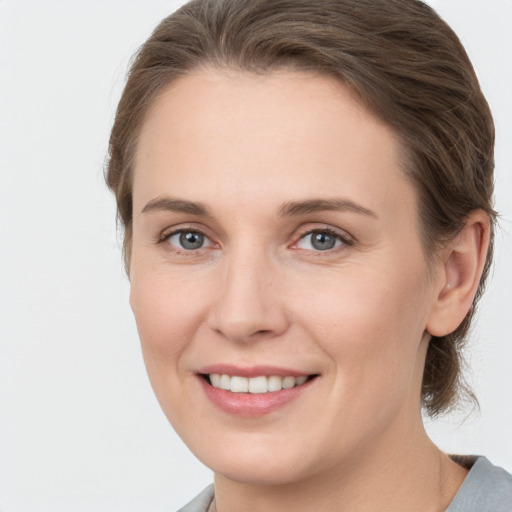 Joyful white young-adult female with medium  brown hair and grey eyes