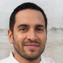 Joyful white young-adult male with short  black hair and brown eyes