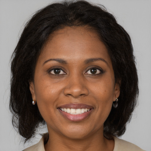 Joyful black young-adult female with medium  brown hair and brown eyes