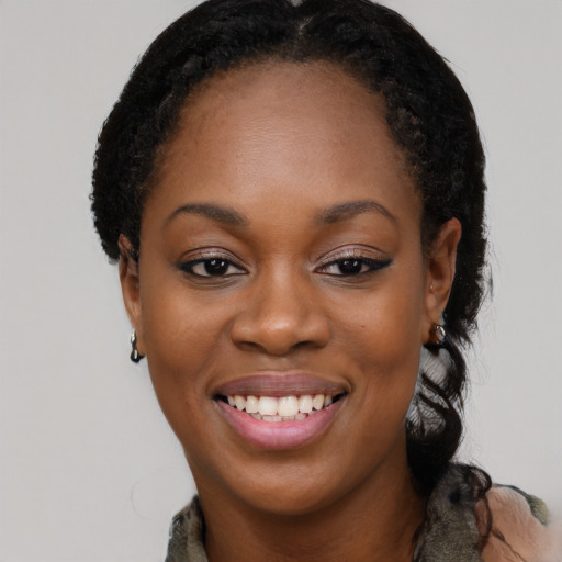 Joyful black young-adult female with long  black hair and brown eyes