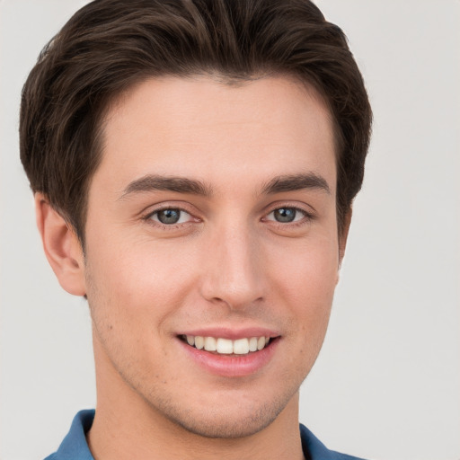 Joyful white young-adult male with short  brown hair and grey eyes