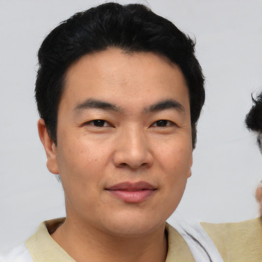 Joyful asian young-adult male with short  black hair and brown eyes