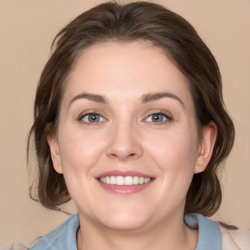 Joyful white young-adult female with medium  brown hair and grey eyes