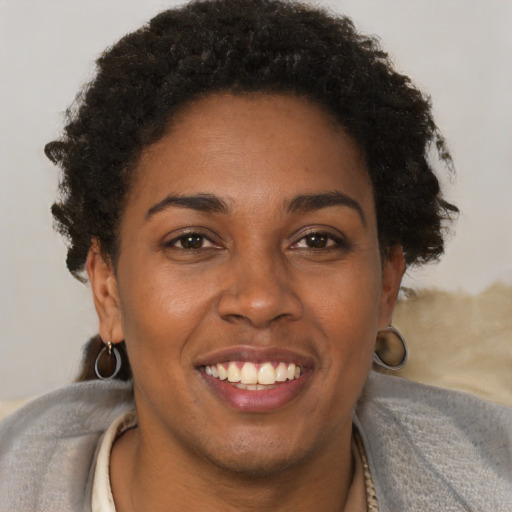 Joyful black young-adult female with short  brown hair and brown eyes