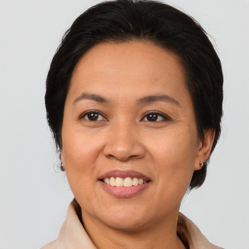 Joyful latino adult female with medium  brown hair and brown eyes