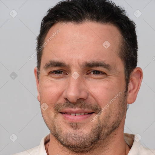 Joyful white adult male with short  brown hair and brown eyes