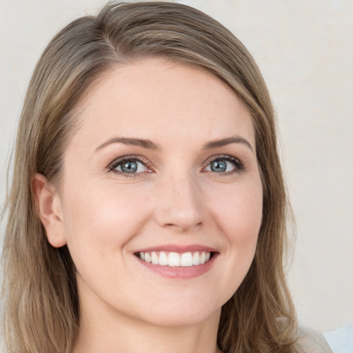 Joyful white young-adult female with long  brown hair and blue eyes