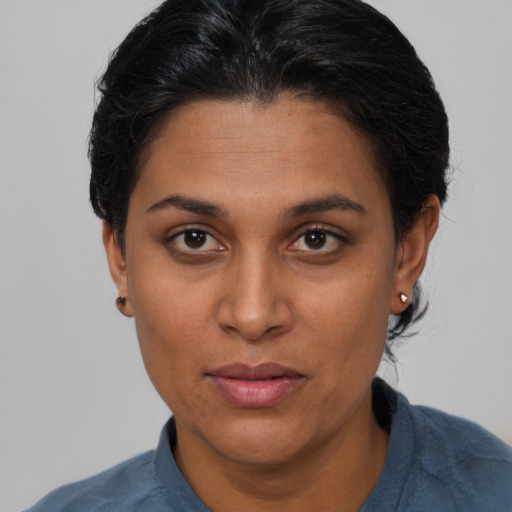 Joyful latino adult female with short  brown hair and brown eyes