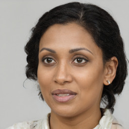 Joyful black adult female with medium  brown hair and brown eyes