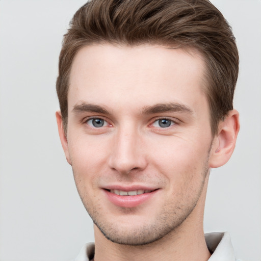 Joyful white young-adult male with short  brown hair and grey eyes