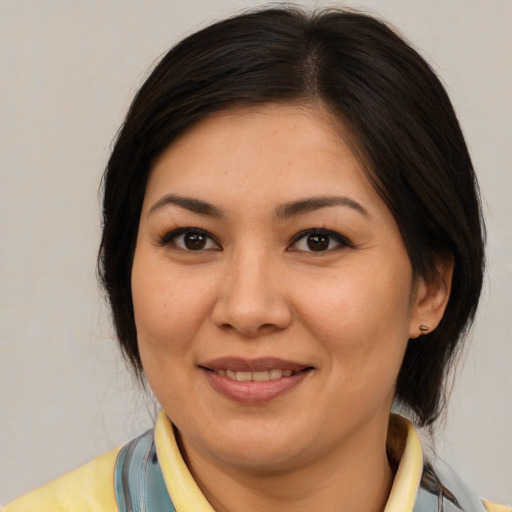 Joyful asian adult female with medium  brown hair and brown eyes