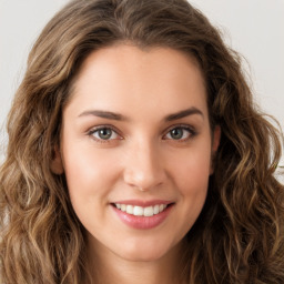 Joyful white young-adult female with long  brown hair and green eyes