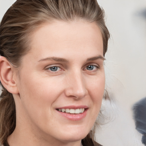 Joyful white young-adult female with medium  brown hair and grey eyes